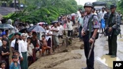 A Myanmar policeman and soldier provide security