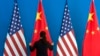 A Chinese woman adjusts the Chinese national flag near U.S. national flags, file photo. 