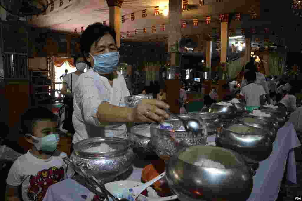 ស្ត្រី​ម្នាក់​កំពុង​រាប់​បាត្រ នៅ​វត្ត​​ថាន់​ រាជធានី​ភ្នំពេញ អំឡុង​​ពេល​​ប្រារព្ធ​ពិធី​បុណ្យ​ចូល​ឆ្នាំ​ខ្មែរ​ថ្ងៃទី​២ នៅ​ថ្ងៃ​ទី​១៤ ខែមេសា ឆ្នាំ​២០២០។ (កាន់ វិច្ឆិកា/VOA)