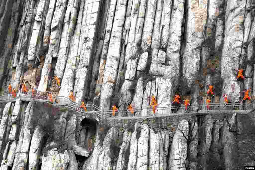 Students from a martial arts school practice Shaolin Kung Fu on cliffs in Dengfeng, Henan Province, China.
