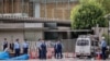 Police investigate a vehicle that crashed into a barricade outside the prime minister's Tokyo residence on Oct. 19, 2024, after a man threw Molotov cocktail-like objects outside the ruling party's headquarters building, hit a riot police vehicle and drove into the barricade.