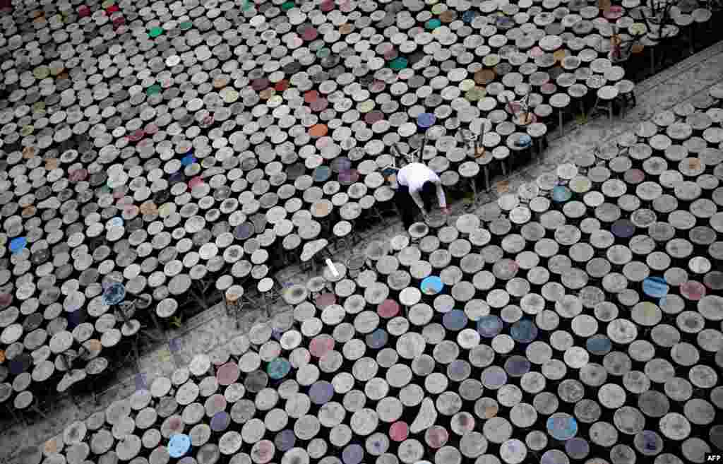Seorang staff membantu mengatur instalasi &quot;kursi&quot; dari seniman China Ai Weiwei yang terbuat dari 6000 kursi tanpa lengan di ruang pameran atrium Martin-Gropius-Bau di Berlin, Jerman. 