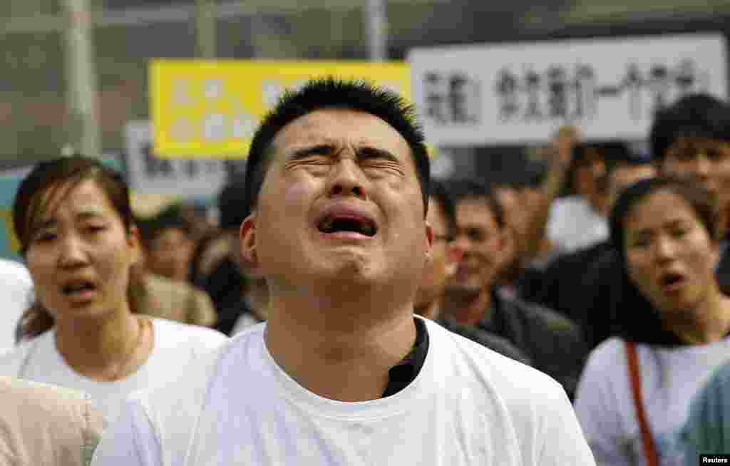 A family member of a passenger on board Malaysia Airlines MH370 cries as he shouts slogans during a protest in front of the Malaysian embassy in Beijing, China.