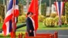 Thailand's Prime Minister Yingluck Shinawatra and China's Premier Li Keqiang listen to national anthems during welcoming ceremony, government house, Bangkok, Oct. 11, 2013.
