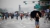 A woman wearing a mask walks past members of conservative civic groups who take part in an anti-government protest, as concerns over a fresh wave of the coronavirus disease (COVID-19) cases grow, in central Seoul