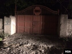 The red metal gate where the tour bus waited for the arrival of police. (S. Lemaire/VOA)