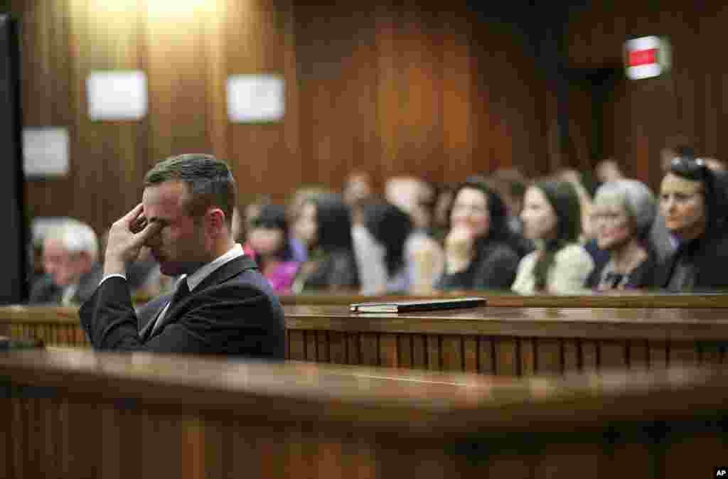 Mantan pelari Olimpiade Afsel, Oscar Pistorius mengusap air matanya dalam pengadilan di Pretoria, Afrika Selatan atas dakwaan membunuh kekasihnya, Reeva Steenkamp.