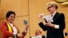 UNHCR goodwill ambassador and actress Cate Blanchett (R) and formerly stateless refugee Maha Mamo (L) show passports during the UNHCR's Executive Committee meeting in Geneva, Switzerland, Oct. 7, 2019.