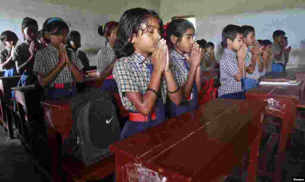 Schoolchildren pray inside their classroom for the victims of Kolkata's collapsed flyover bridge, in Agartala, India. The bridge, which was under construction, killed at least 23 people and injured 80 more on Thursday.