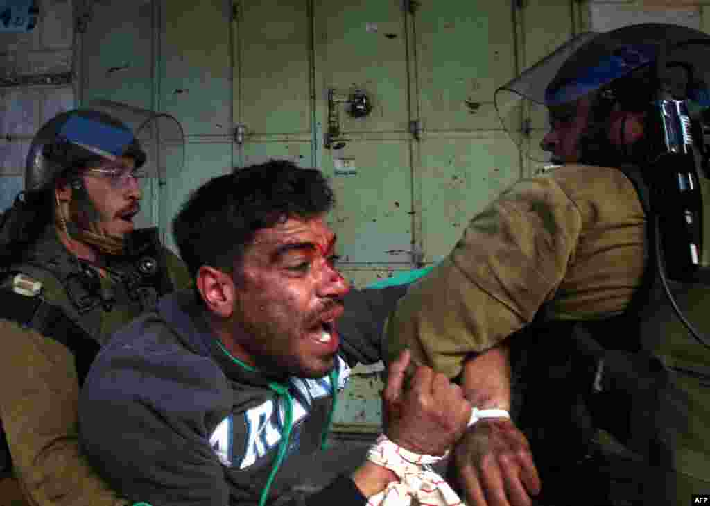 Demonstran Palestina melawan saat ditahan tentara Israel dalam bentrokan di kota tua Hebron, menyusul demonstrasi yang menuntut pembukaan kembali jalan Shuhada, yang dulu merupakan jantung kota.&nbsp;