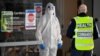 Medical workers speak at the entrance of the Epping Gardens aged care facility in the Melbourne suburb of Epping on July 29, 2020, as the city battles fresh outbreaks of the COVID-19 coronavirus. 