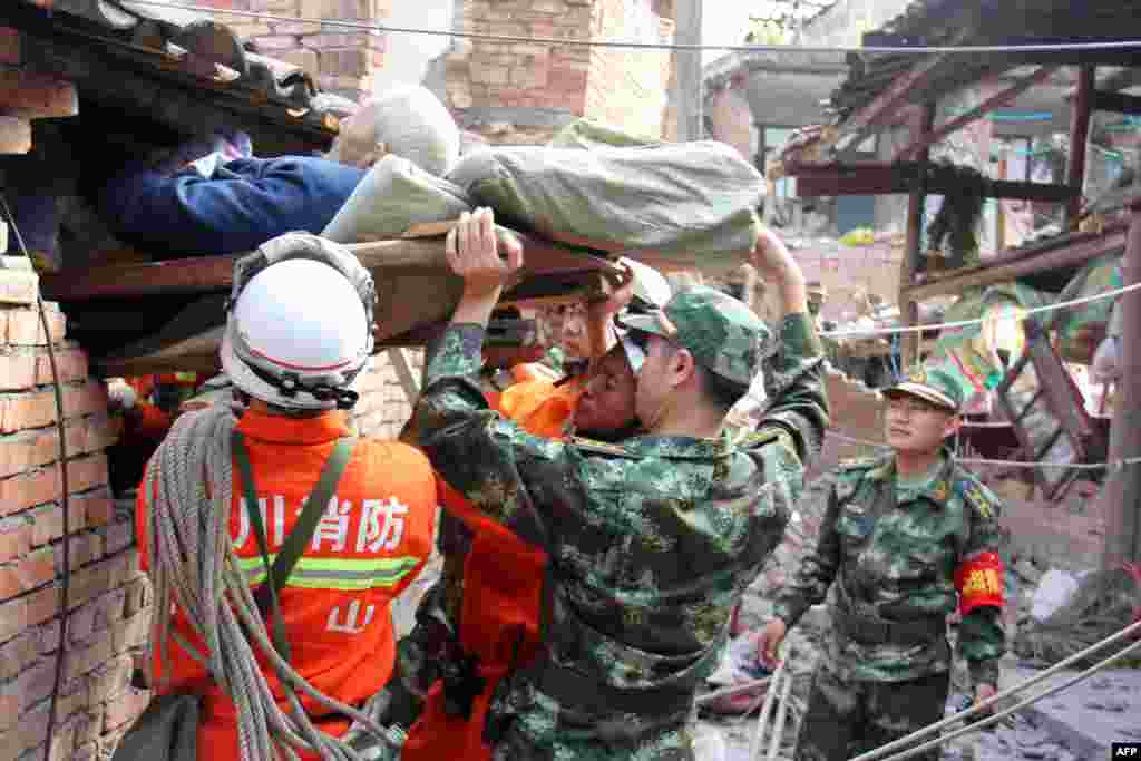 Regu penyelamat berusaha mengeluarkan seorang laki-laki lanjut usia yang lumpuh dari rumahnya yang rusak di kota Qingren di Kabupaten Lushan yang hancur akibat gempa berkekuatan 7.0 menngoncang kota Ya&#39;an di Provinsi Sichuan, China barat daya 