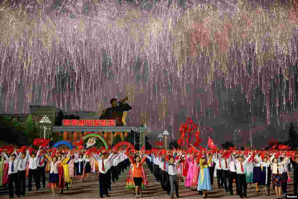 Fireworks explode over participants in a mass dance in the capital's main ceremonial square, a day after the ruling Workers' Party of Korea party wrapped up its first congress in 36 years, in Pyongyang, North Korea, May 10, 2016.