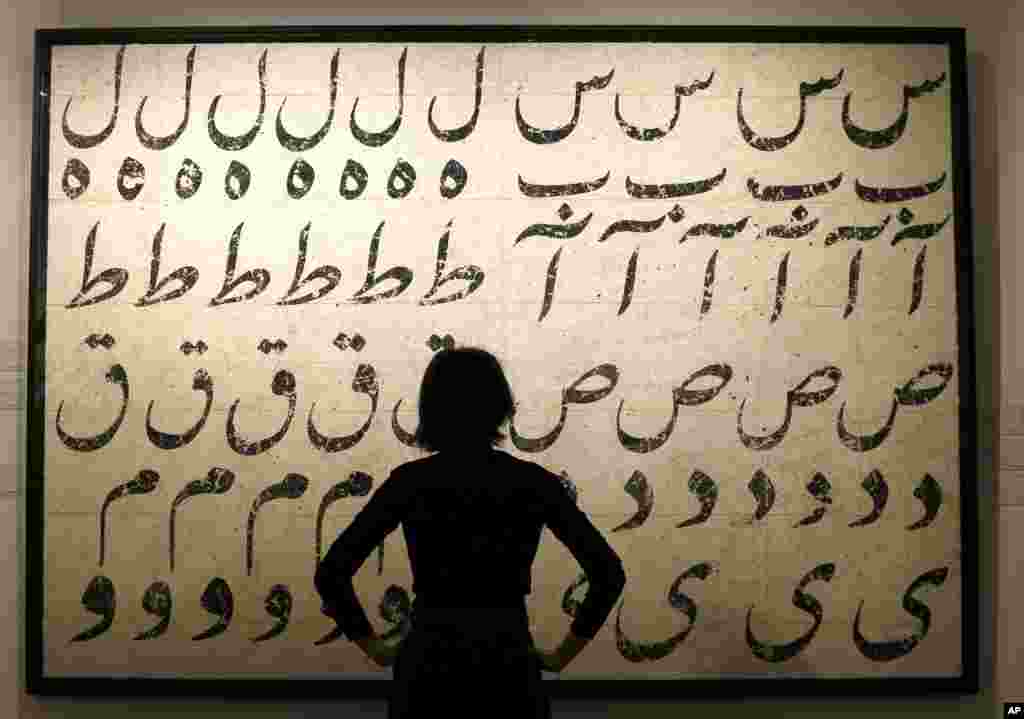 A Sotheby's employee looks at a painting by Farhad Moshiri, Untitled from The Jar Series, at Sotheby's auction rooms in London. The painting is expected to bring 100,000-150,000 UK pounds (141,882-212,824 US dollars) when it is auctioned in the first-ever single owner Modern and Contemporary Iranian sale, called Alchemy: Objects of Desire on April 21.