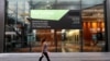 A woman walks past a lease sign at a commercial building in Sydney, Wednesday, Sept. 2, 2020. Australia's economy has suffered its sharpest quarterly drop since the Great Depression.