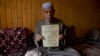 Ghulam Mohammad Zargar, an elderly Kashmiri man shows his domicile document locally know as "State Subject" which was only held by permanent residents of Jammu and Kashmir in Srinagar, Indian controlled Kashmir, Oct. 31, 2019.