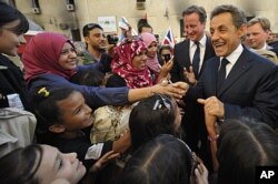 Nicolas Sarkozy (à dr.) et David Cameron saluent la foule à Benghazi (15 septembre 2011)