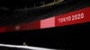 Un membre de l'équipe de sécurité monte la garde devant des stands vides au Sapporo Dome à Sapporo, au Japon, le 21 juillet 2021.