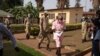 Paul Rusesabagina (2e à droite, en uniforme rose de détenu) arrive avec des agents du Service correctionnel du Rwanda à la Cour de justice de Nyarugenge à Kigali, au Rwanda, le 25 septembre 2020.