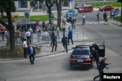 Službenici sigurnosti premještaju slovačkog premijera Roberta Fica u automobil nakon incidenta s pucnjavom, nakon sastanka slovačke vlade u Handlovi, Slovačka, 15. maja 2024. (REUTERS/Radovan Stoklasa)