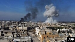 Smoke billows over the town of Saraqib in the eastern part of the Idlib province in northwestern Syria, following bombardment by Syrian government forces, on February 27, 2020-