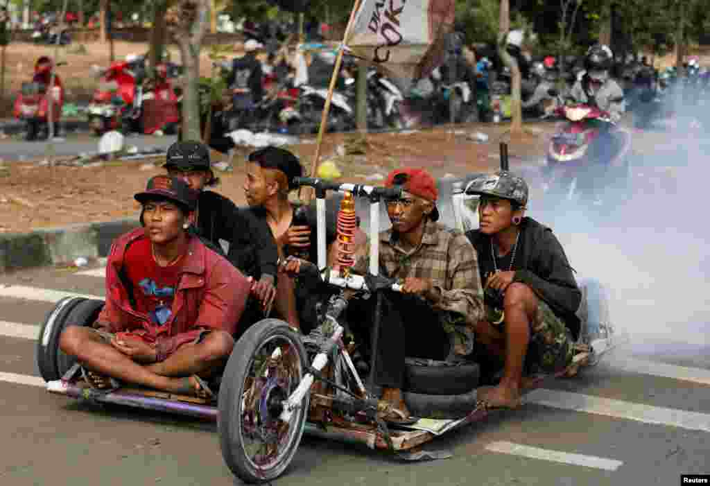 អ្នក​និយម​ម៉ូតូ Vespa បើកម៉ូតូ​របស់​ខ្លួន​នៅក្បែរ​កន្លែង​ប្រារព្ធ​ពិធី​ចុងសប្តាហ៍​សម្រាប់​អ្នក​និយម​ម៉ូតូ Vespas ខ្លាំង​ក្នុង​ទីក្រុង​ Semarang ទីក្រុង Java កណ្តាល​ ប្រទេស​ឥណ្ឌូណេស៊ី។