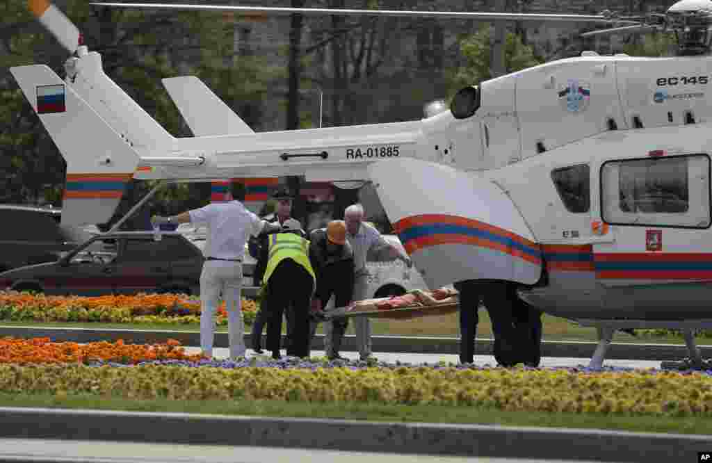 Paramedics carry an injured&nbsp;woman to a medical helicopter from a subway station after a rush-hour subway train derailment, in Moscow, July 15, 2014.