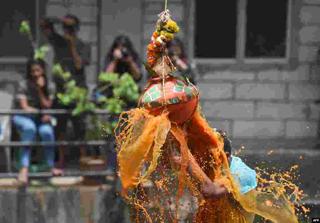 សាសនិក​ហិណ្ឌូ​ម្នាក់​បំបែក​ក្អម dahi-handiដែល​ត្រូវ​បាន​ព្យួរ​នៅ​លើមនុស្ស​ពីរ៉ាមីត​អំឡុង​ពិធី​បុណ្យ​ Janmashtami ដើម្បី​អបអរ​ការ​ចាប់​កំណើត​របស់​ព្រះហិណ្ឌូ Krishna ក្នុង​ទីក្រុង​ Mumbai​ ប្រទេស​ឥណ្ឌា។