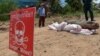 រូបឯកសារ៖ សមាជិក​មជ្ឈ​មណ្ឌល​សកម្ម​ភាព​កម្ចាត់​មីន​កម្ពុជា​(CMAC) (ឆ្វេង) និង​ប៉ូលិស​ឈរ​យាម​ពី​ក្រោយ​គ្រាប់​បែក​ម៉ាក ៨២ នៅ​ខេត្ត​កណ្ដាល កាលពី​ថ្ងៃ​ទី​២១ ខែ​ឧសភា ឆ្នាំ​២០១៥។