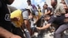 Syrian rescuers and civilians pull a man from the rubble of a building following an airstrike by regime forces in Maar Shurin on the outskirts of Maaret al-Numan in northwest Syria, July 16, 2019. 