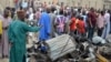 People look at the damage on March 2, 2014, after two explosions struck Nigeria's restless northeastern city of Maiduguri, a stronghold of Boko Haram Islamists.