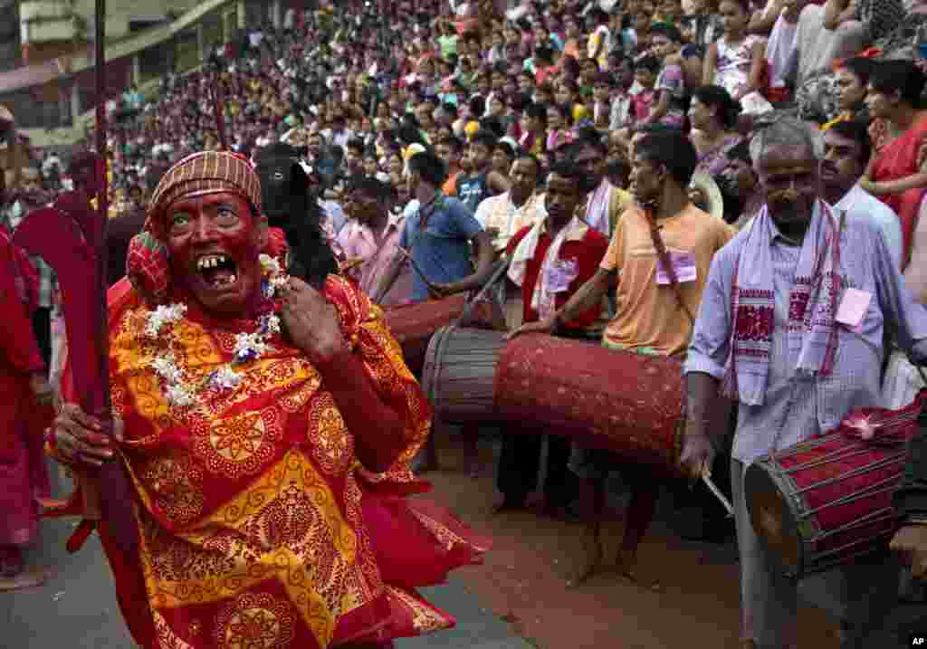 Seorang pendeta Hindu memanggul kambing untuk dikorbankan pada festival Deodhani di Candi Kamakhya, Gauhati, India.