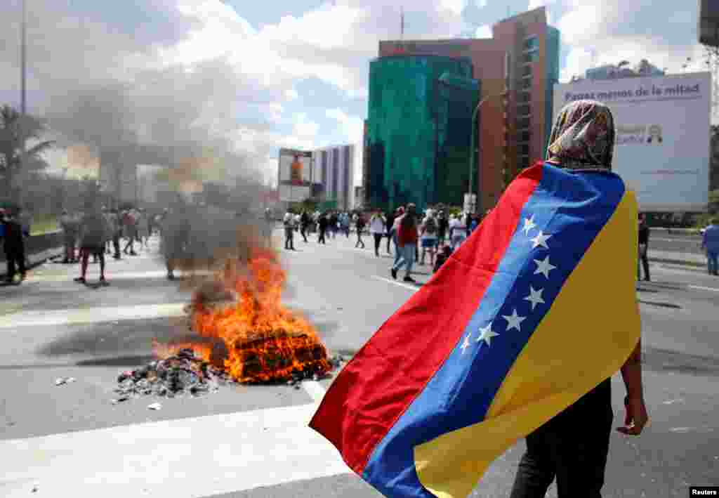 Para pengunjuk rasa bentrok dengan polisi anti huru-hara selama unjuk rasa menuntut pelaksanaan referendum untuk menurunkan Presiden Venezuela, Nicolas Maduro di Caracas, Venezuela.