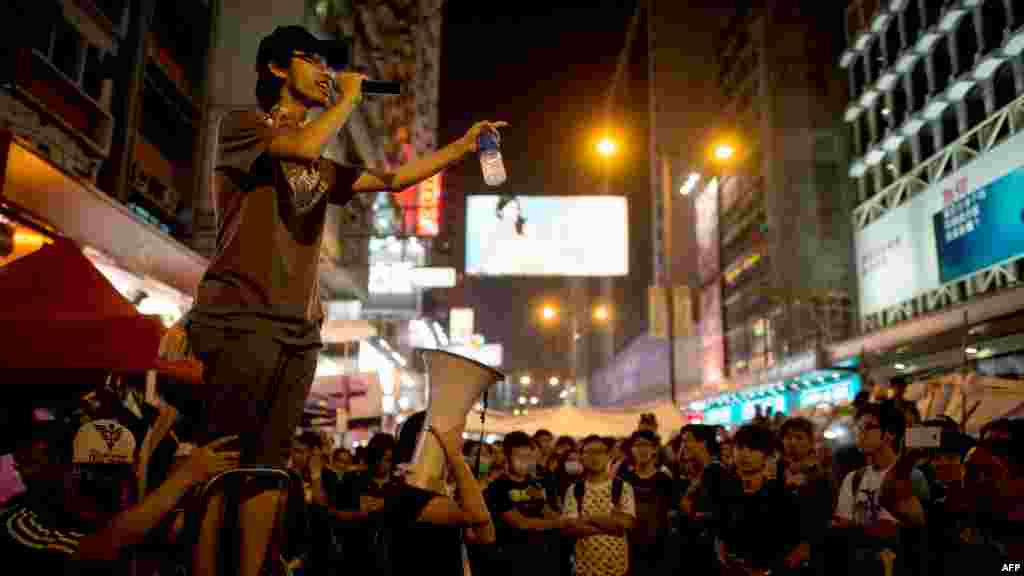 Seorang demonstran pro-demokrasi berbicara dengan pengeras suara kepada para pemrotes di distrik Mong Kok, Hong Kong (5/10). (AFP/Ed Jones)