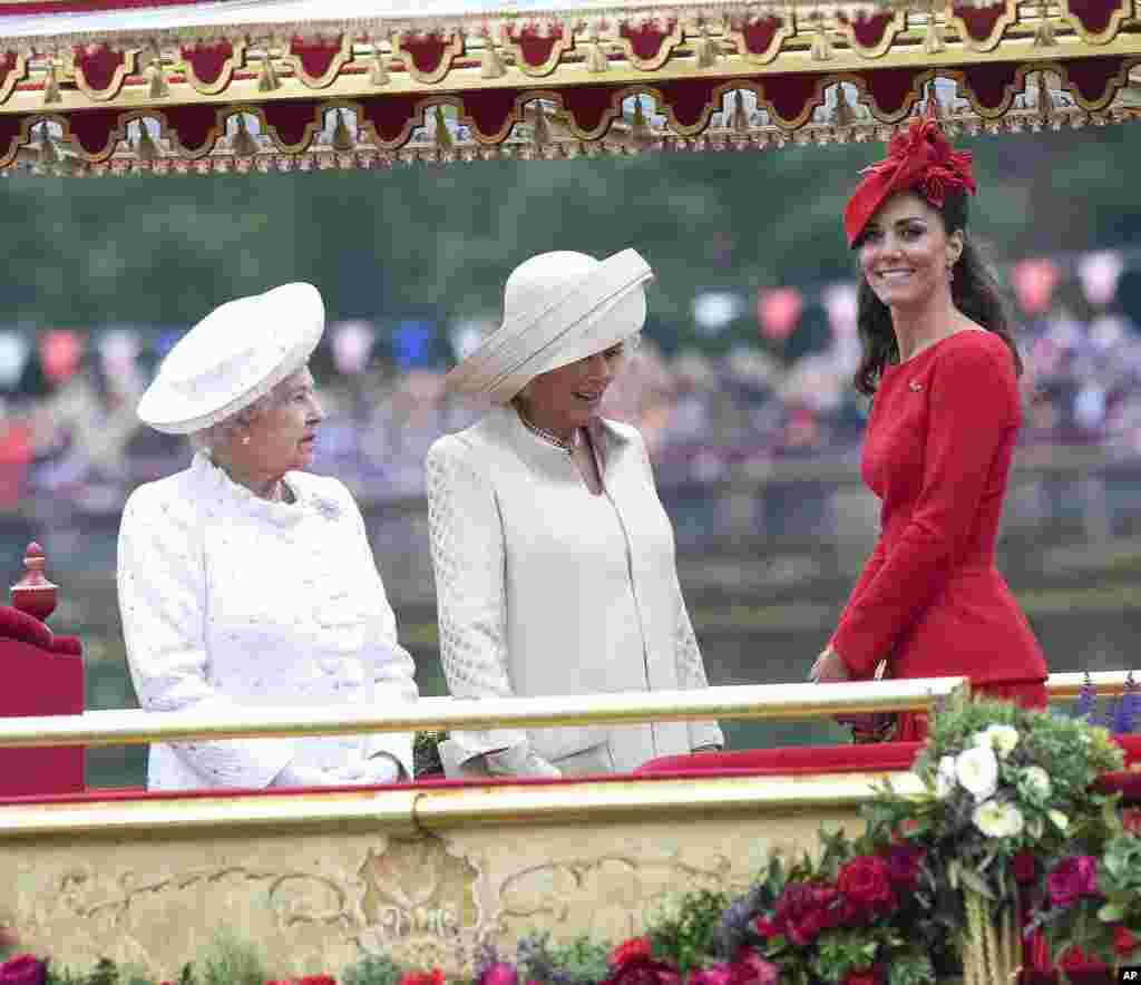 Britain&#39;s Kate, Duchess of Cambridge, right, Camilla, Duchess of Cornwall, center, and Queen Elizabeth, look at the proceedings on the royal barge, the principal boat of a flotilla of 1,000 vessels.