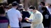 A medical staff member takes details from people queuing at a COVID-19 testing site in Adelaide, Nov. 17, 2020.