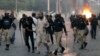 Police detain a supporter of the Tehreek-e-Labbaik Pakistan party during clashes with its members in Karachi, Pakistan, Oct. 13, 2024.
