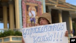 អ្នក​តវ៉ាម្នាក់​លើកបដាតវ៉ា​ដែល​សរសេរ​ថា៖ «ជួយ​ប្រជាជន​បឹងកក់​ផង ជួយផង!!!»។