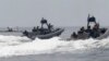 FILE - U.S. and Philippine Navy servicemen aboard patrol boats conduct a boat manoeuvre exercise past a fishing boat during a joint annual military exercise called "Carat" at the former U.S. military base Sangley Point in Cavite city, west of Manila, June