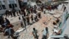 Palestinians inspect a school sheltering displaced people following an Israeli strike in Deir al Balah in the central Gaza Strip on July 27, 2024.
