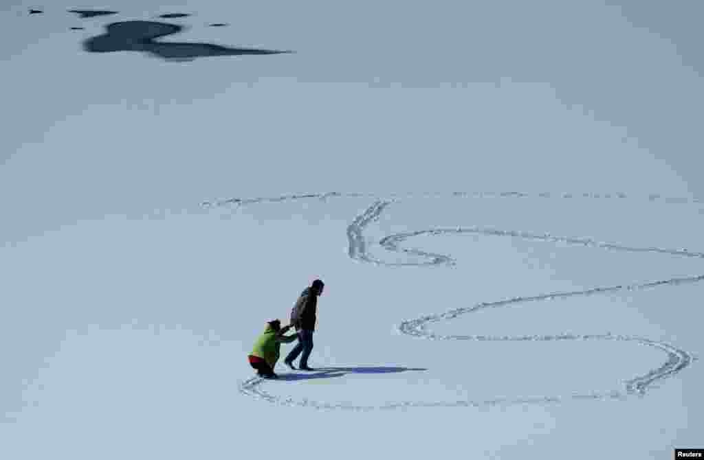 People play on frozen water in Dalian, Liaoning province, China, Feb. 24, 2016.