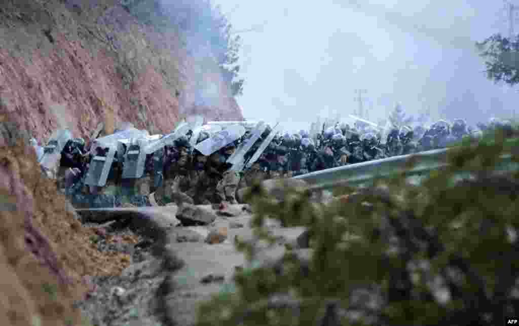 Police hold up their shields as they clash with protesters during a demonstration against the building of a mine in Artvin, northeastern Turkey.