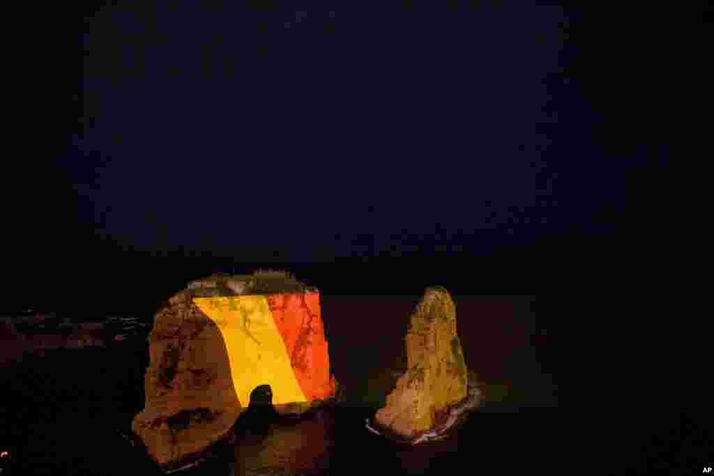 The landmark Raouche sea rock in Beirut, Lebanon, is illuminated in the colors of the Belgium national flag to show solidarity with Belgium after the attacks in Brussels earlier this week.