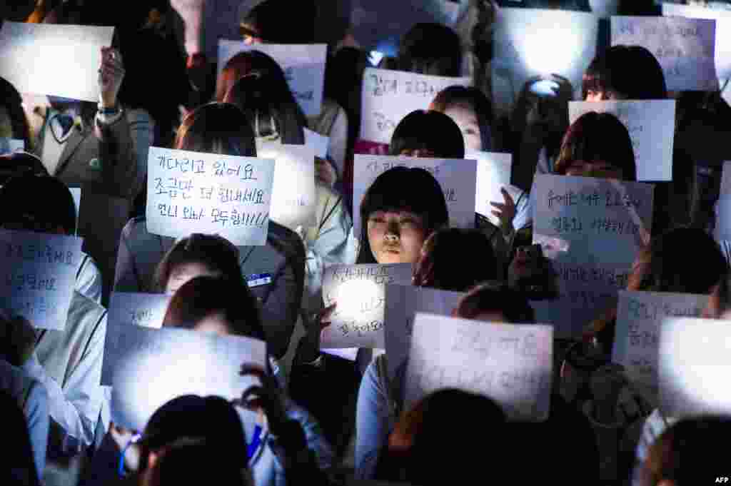 Murid-murid di SMU Danwon di Ansan memegang pesan-pesan untuk murid-murid yang menjadi korban dalam feri yang terbalik di tengah laut di Korea Selatan. &nbsp;