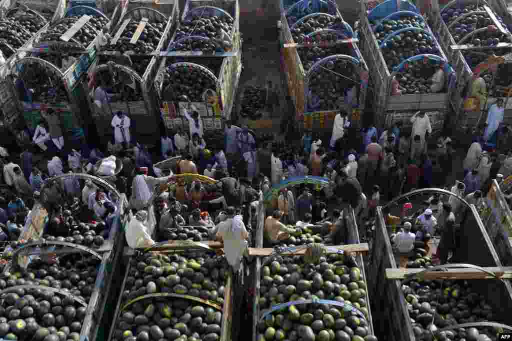 Pakistani farmers gather at a fruit market to sell watermelons in Lahore.