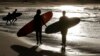 In this April 28, 2020, file photo, surfers walk along Bondi Beach in Sydney as coranavirus pandemic restrictions are eased. U.S. biotechnology company Novavax began injecting a coronavirus vaccine candidate into people in Australia.