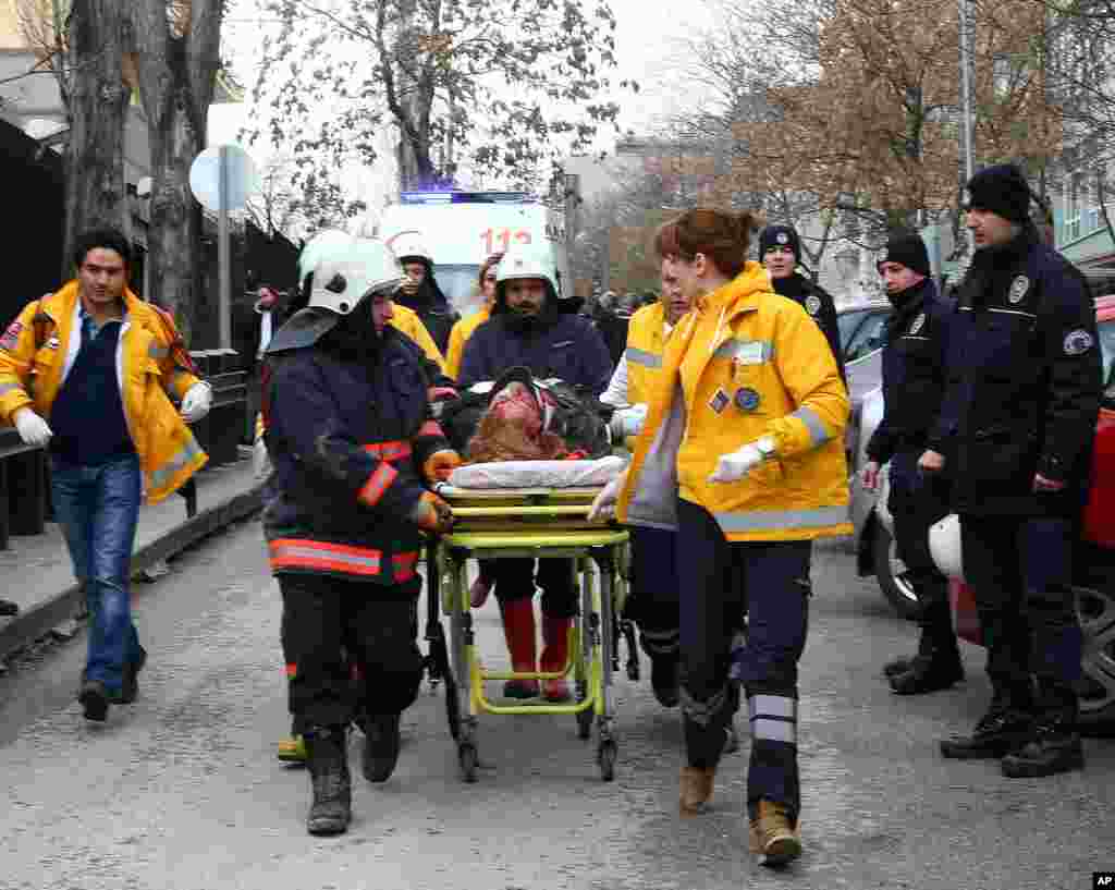 Görevliler patlamada yaralanan bir kişiyi ambulansa hastaneye taşıdı.