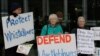 FILE - In this June 27, 2019, photo, whistleblower supporters demonstrate in Canberra, Australia, after a former army lawyer was charged with leaking documents alleging misconduct in Afghanistan.