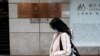 FILE - A woman walks in front of the China Evergrande Centre building sign in Hong Kong, China, Dec. 7, 2021