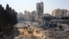 People walk on rubble at the damaged building complex of the U.N. Relief and Works Agency in Gaza City on July 12, 2024, following the withdrawal of Israeli troops from the area. Israel wants to dismantle the UNRWA, but U.N. leader Antonio Guterres says there are no alternatives.